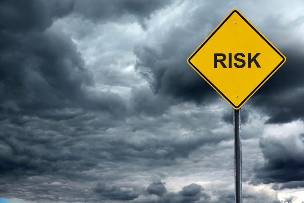 road warning sign with text risk in front of storm cloud background